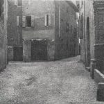 Piazzola dei Guidoscalchi sopra la quale sorgeva porta di piazza Maggiore. - A destra abbiamo la chiesa dello Spirito Santo, di qua da essa, sulla via Val d'Aposa che in parte vediamo, correva l'Aposa e sopra vi sorgeva il ponte della Cittadella dal quale fu principiato il muro che doveva togliere dalla vista pubblica le case delle dame cortesi che abitavano nel lato sud del vicolo che vediamo in fondo a destra il quale finiva in via S. Mamolo.
In fondo a sinistra: la via dello Spirito Santo. Immagine tratta dal libro di Angelo Finelli Bologna nel Mille - Identificazione della cerchia che le appartenne a quel tempo, edito a Bologna dagli Stabilimenti Tipografici Riuniti nel 1927.