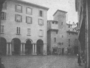 mmagine tratta dal libro di Angelo Finelli Bologna nel Mille - Identificazione della cerchia che le appartenne a quel tempo, edito a Bologna dagli Stabilimenti Tipografici Riuniti nel 1927. La didascalia dell'immagine è: Piazza Mercanzia. A sinistra casa Masotti, via Caprarie e torre Riccadonna.