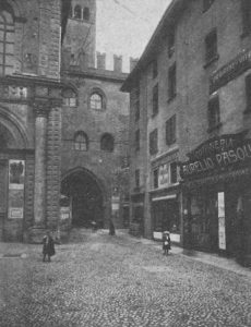 Seguito della via Orefici. Lato Nord di Piazza Uccelli. In fondo Voltone del Podestà e via Accuse. Nell'ultima casa in angolo con via Accuse vi fu la chiesa di Santa Giusta, sopressa verso il 1200 (Angelo FInelli).