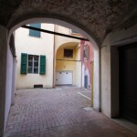 L'uscita dal voltone. Al centro si vede il portone che chiude l'accesso alle autovetture su via San Vitale.