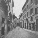 Via Caprarie vista da ponente. Nella seconda casa a destra ebbe sede la società dei Beccai. Nella casa attigua si vede il voltone della via Capraria che andava alla via Clavature.