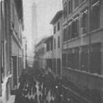 Via Rizzoli vista da via della Canepa. Tra la terza e quarta casa c'è via Spaderie. Dove c'è il primo palazzo sulla destra era la chiesa di San Michele del Mercato di Mezzo. Chiusa nel 1808 (18 agosto) venduta dai Buttrigari a tale Frignani che vi pose un mangano e l'aperse ad uso negozio nel 1811. Immagine e testo tratti dal libro di Angelo Finelli Bologna nel Mille - Identificazione della cerchia che le appartenne a quel tempo, edito a Bologna dagli Stabilimenti Tipografici Riuniti nel 1927.