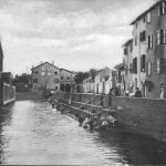 Il Canale di reno lungo via della Grada. In fondo si vede l'Opificio Idraulico descritto sopra. Dietro la chiesa di San Valentino e di S.Maria della Grada. A sinistra la torretta degli scomparsi Bagni del Reno. La fotografia fu scattata dal Ponte della Carità.