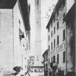 Via Rizzoli come appariva prima degli interventi di demolizione degli isolati sul lato destro dove è ben visibile l'Albergo dei quattro Pellegrini.
A sinistra si vede l'imbocco di via Cavaliera (poi via Guglielmo Oberdan).