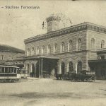 Tram, carrozze a cavalli e una autovettura davanti alla Stazione.